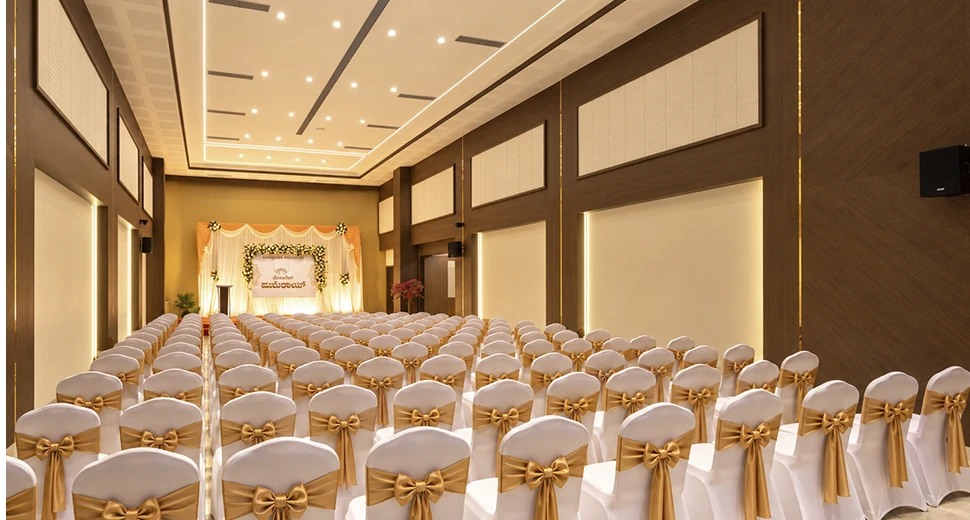 Raised ceremonial stage with lighting in Sidhvin Banquet Hall at Hotel Pumerai Honnavar