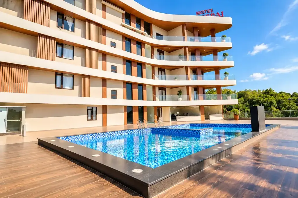 Hotel Pumerai curved boutique facade and glass-edge rooftop swimming pool on NH-66
